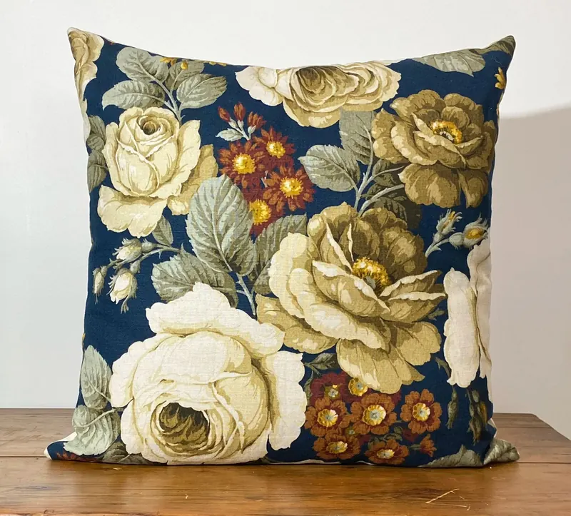 A finished cushion with vintage floral fabric in the workshop
